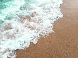 Oceano ola en arenoso playa foto