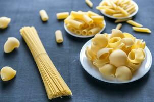 Various types of pasta on the dark background photo