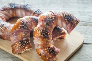 Bagels with sesame wrapped in bacon rashers photo