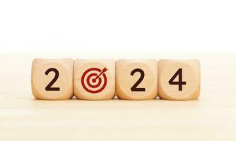 2024 business goals concept. Wooden blocks with 2024 number and goal target icon. Copy space photo