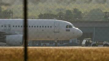 Phuket, Thailand Februar 19, 2023 - - Traktor ziehen Flugzeug Airbus a320 von thaivietjet beim Phuket Flughafen, Seite Sicht. Flugzeug auf das Flugplatz. Tourismus und Reise Konzept. video