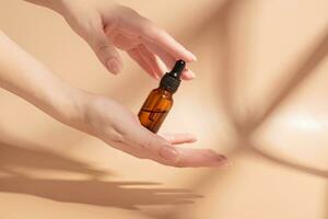 Dropper bottle with beauty serum in female hands. Skin care treatment, dayly routine for healthy skin. photo