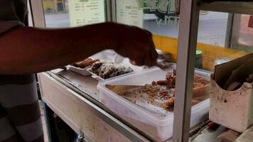 rua Comida vendedores preparando banana crocantes conhecido Como crocantes bananas dentro indonésio. coberto com queijo e chocolate, elas estão muito crocantes fora. video