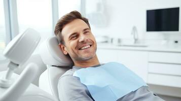 Perfecto sonrisa. retrato de contento paciente en dental silla. hombre con un blanco sonrisa foto