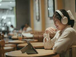 asiático adolescente niña utilizando tableta acecho en línea multimedia en café tienda foto