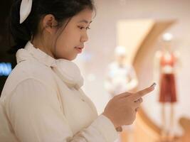 In supermarket closeup hand young teen asian woman using social media on smart phone, Shopping online sale, Shopping mall photo