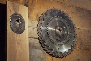 set of circular saw blades hangs on a wooden wall in the carpentry workshop. Circular saw. old rustic carpentry workshop. photo