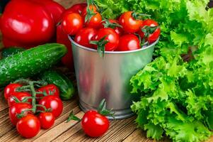 conjunto de vegetales para ensalada, pepinos, campana pimientos, Fresco rojo Cereza Tomates en un de madera mesa arriba.arriba vista. cosecha. natural alimento. foto