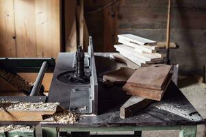 carpenter's workbench with many different wood blanks and planks of wood.  rustic old carpenter's workshop. photo