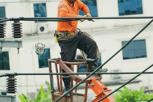 High voltage power line maintenance. Electrician at work. Electrical technician repairing cable wire. High voltage power line construction. Danger of wiring and electrical wires. Work with safety. photo