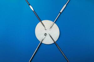set of cosmetic products for manual cleaning of the face on a blue background with a cotton discs. Stainless steel. Problem skin. photo