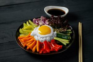 Close-up of a Korean dish, with a variety of appetizers with vegetables and eggs. Diet. bibimbap. Top view. Round plate. photo