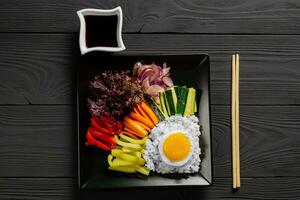 Close-up of Korean dish, with variety of appetizers with vegetables and eggs. Diet. bibimbap. Top view. square plate. photo