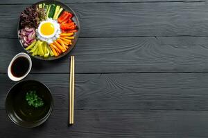 Korean dish, with a variety of appetizers with vegetables and eggs. Diet. bibimbap. View from above. Round plate. Text space. photo