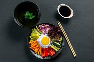 Korean dish, with a variety of appetizers with vegetables and eggs. Diet. bibimbap. Top view. Round plate. photo