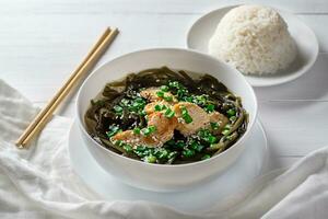 Korean seaweed soup with meat in a white bowl and boiled rice. Birthday soup. Traditional Korean cuisine. Healthy Eating. Pregnancy. Custom. photo