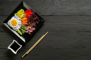 Korean dish, with a variety of appetizers with vegetables and eggs. Diet. bibimbap. Top view. square plate. Place for text. photo