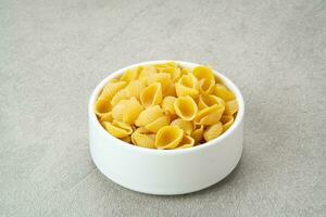 Raw Pasta Conchiglie on the table, copy space photo