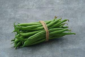Buncis or Fresh raw string bean, legumes contain protein on dark background photo