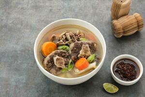 Sop Buntut or Oxtail Soup with carrot and potatoes. Indonesian traditional food photo