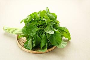 Bunch of raw fresh spinach leaves on wooden table photo