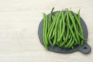 Buncis or Fresh raw string bean, legumes contain protein on dark background photo