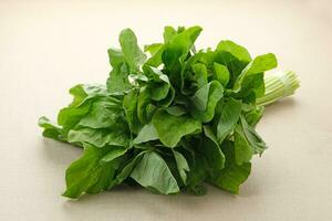 Bunch of raw fresh spinach leaves on wooden table photo