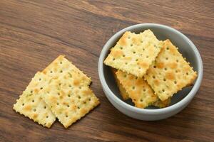 Stacked square biscuits, with a sprinkling of dry vegetables, savory and crunchy photo