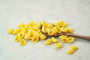 Raw Pasta Conchiglie on the table, copy space photo