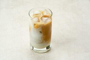 Iced caramel macchiato coffee in glass on wooden table photo