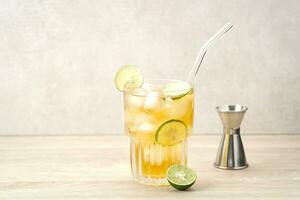 Iced tea with lime on a wooden table, refreshing drink photo