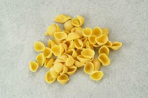 Raw Macaroni pasta served on grey background photo