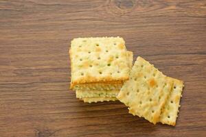 Stacked square biscuits, with a sprinkling of dry vegetables, savory and crunchy photo