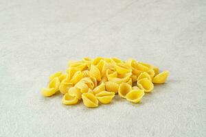 Raw Pasta Conchiglie on the table, copy space photo