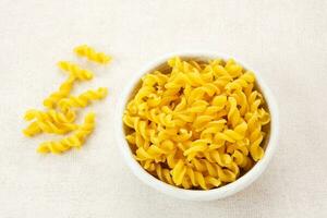 Raw Macaroni pasta served on white bowl photo