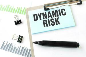 Paper plate, marker, diagram, chart and office tools. Text DYNAMIC RISK photo