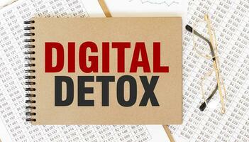 Craft colour notepad with text DIGITAL DETOX. Notepad with eyeglasses and text documents. Business concept photo