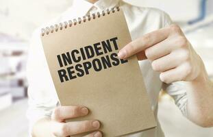 Text INCIDENT RESPONSE on brown paper notepad in businessman hands in office. Business concept photo