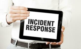 Text INCIDENT RESPONSE on tablet display in businessman hands on the white background. Business concept photo