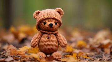 a crocheted teddy bear sitting in the leaves generative ai photo