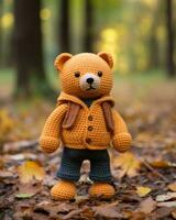 a crocheted teddy bear wearing a jacket in the woods generative ai photo