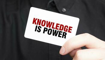 Businessman holding a card with text KNOWLEDGE IS POWER, business concept photo