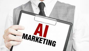 AI MARKETING inscription on a notebook in the hands of a businessman on a gray background, a man points with a finger to the text photo