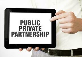 Text PUBLIC PRIVATE PARTNERSHIP on tablet display in businessman hands on the white background. Business concept photo