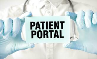 Doctor holding card in hands and pointing the word PATIENT PORTAL photo