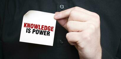 Businessman holding a card with text KNOWLEDGE IS POWER, business concept photo