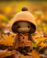 an orange crocheted doll sitting in the leaves generative ai photo