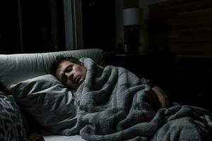 a man is sleeping in bed with a blanket generative ai photo