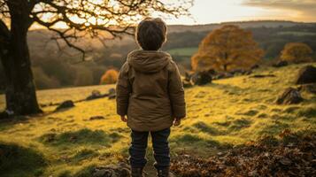 un joven chico en pie en el medio de un campo a puesta de sol generativo ai foto