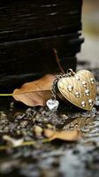 a heart shaped pendant on the ground next to some leaves generative ai photo